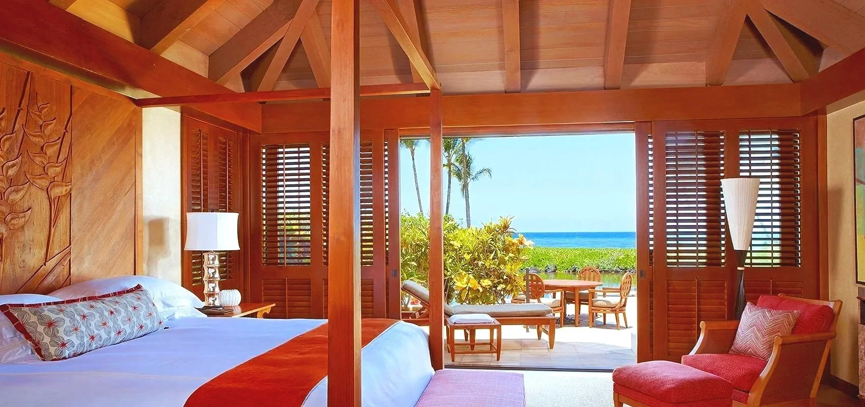 Open Hawaiian bedroom with louvered doors and an ocean view