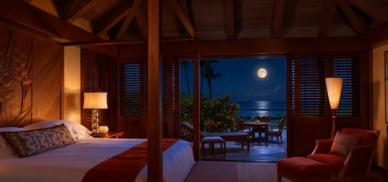Open Hawaiian bedroom with louvered doors and an ocean view